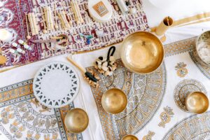 Colorful flat lay of a meditation setup with singing bowls and ethnic textiles for relaxation.